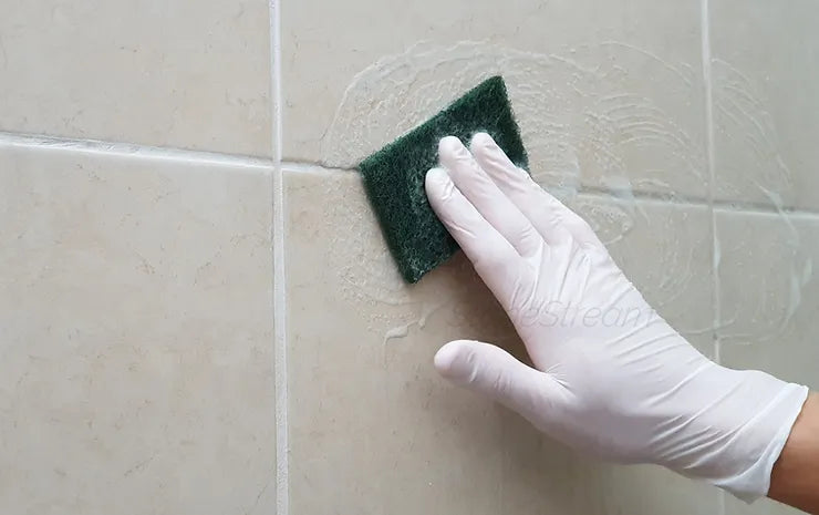 Nettoyage des joints de douche avec une brosse et une solution pour des carreaux sans moisissure